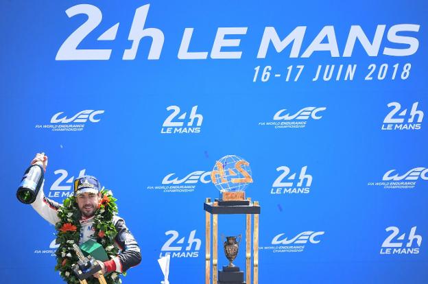 Alonso, en el podio de Le Mans, con su trofeo y una botella de champán. 