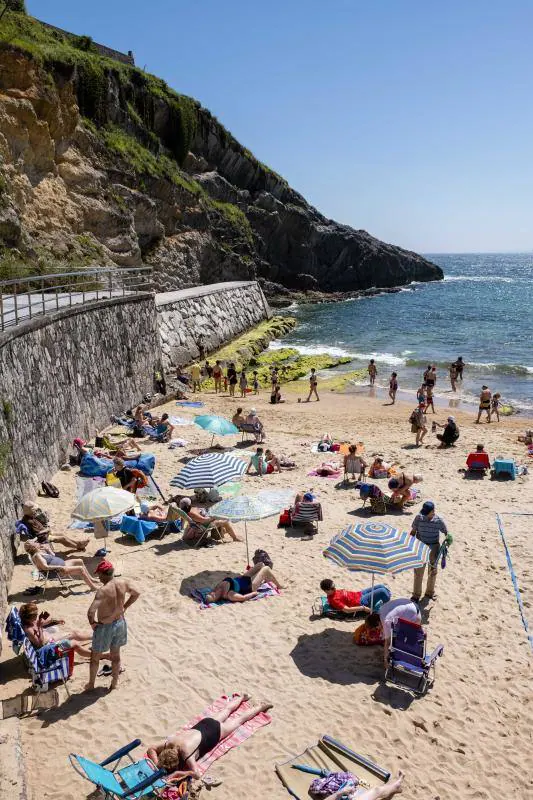 Miles de personas disfrutan del primer fin de semana del verano en las playas de Asturias. Arenales como San Lorenzo, en Gijón, o Rodiles, en Villaviciosa, están a rebosar. 