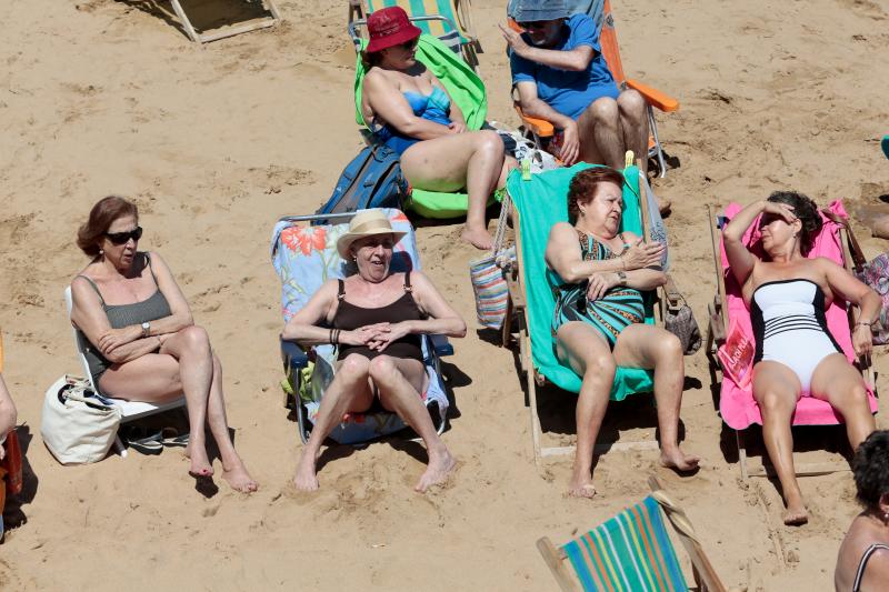 Miles de personas disfrutan del primer fin de semana del verano en las playas de Asturias. Arenales como San Lorenzo, en Gijón, o Rodiles, en Villaviciosa, están a rebosar. 