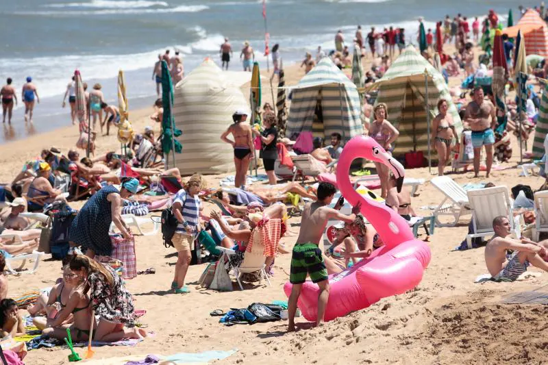 Miles de personas disfrutan del primer fin de semana del verano en las playas de Asturias. Arenales como San Lorenzo, en Gijón, o Rodiles, en Villaviciosa, están a rebosar. 