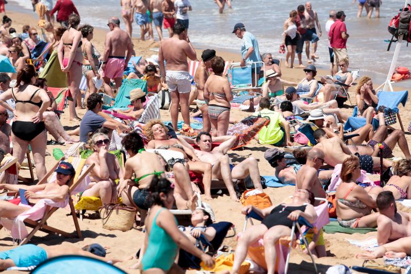 Miles de personas disfrutan del primer fin de semana del verano en las playas de Asturias. Arenales como San Lorenzo, en Gijón, o Rodiles, en Villaviciosa, están a rebosar. 