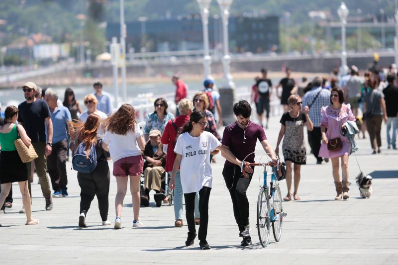 Miles de personas disfrutan del primer fin de semana del verano en las playas de Asturias. Arenales como San Lorenzo, en Gijón, o Rodiles, en Villaviciosa, están a rebosar. 