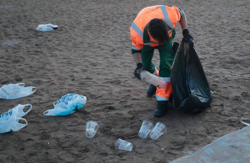 La fiesta de San Juan ha dejado toneladas de basura en la playa de Poniente. Desde antes del amanecer, operarios de Emulsa trabajan en la recogida de los residuos para dejar listo el arenal para un nuevo día de pleno verano.
