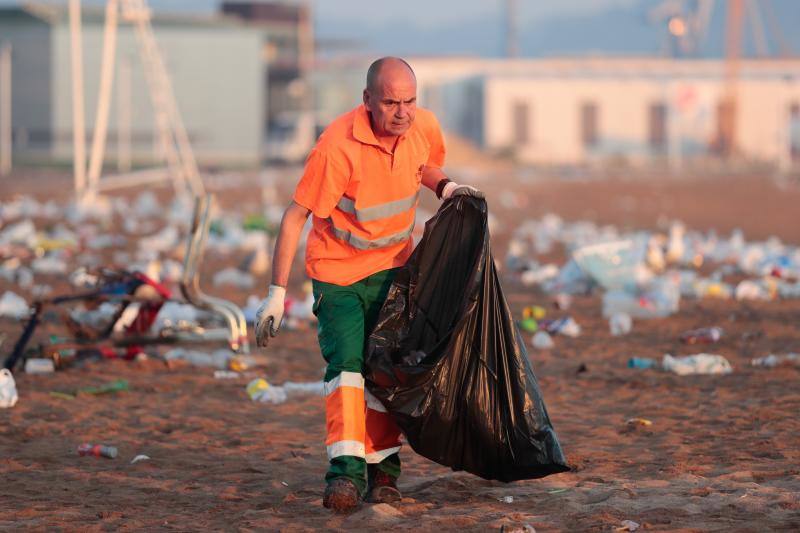 La fiesta de San Juan ha dejado toneladas de basura en la playa de Poniente. Desde antes del amanecer, operarios de Emulsa trabajan en la recogida de los residuos para dejar listo el arenal para un nuevo día de pleno verano.