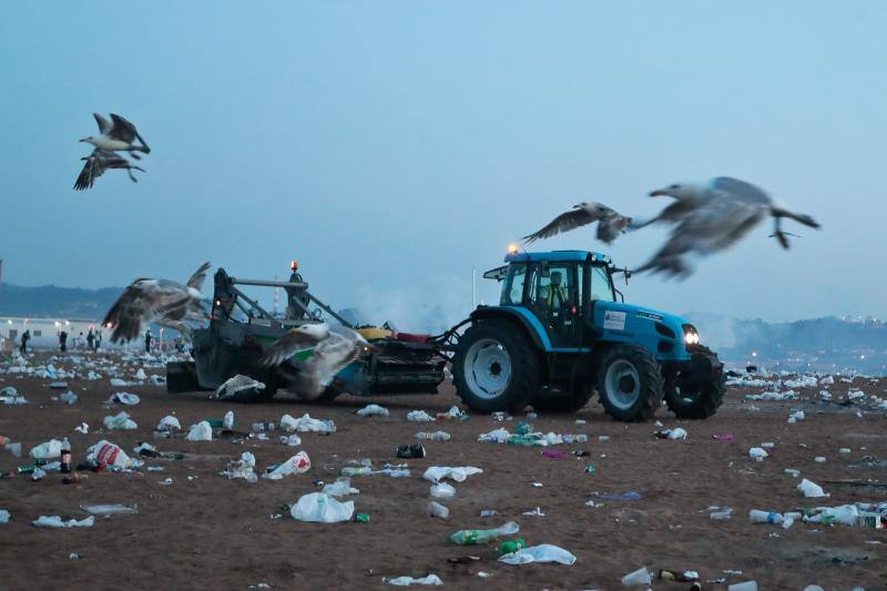 La fiesta de San Juan ha dejado toneladas de basura en la playa de Poniente. Desde antes del amanecer, operarios de Emulsa trabajan en la recogida de los residuos para dejar listo el arenal para un nuevo día de pleno verano.