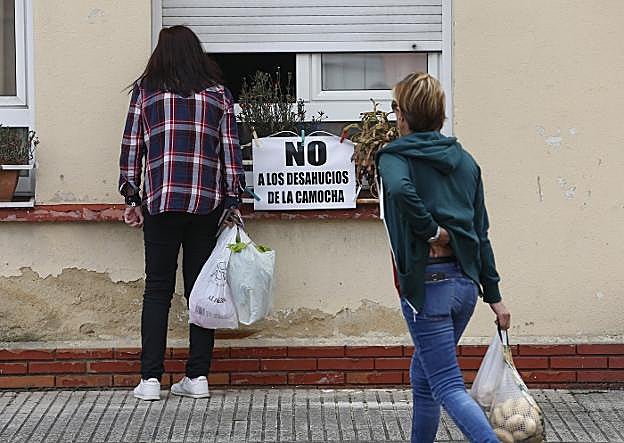 Pancarta contra los desahucios colocada en la ventana de una de las viviendas del poblado. 