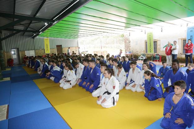 Los jóvenes judocas asistentes a la concentración descansan sobre el enorme tatami instalado en el camping de Vidiago.
