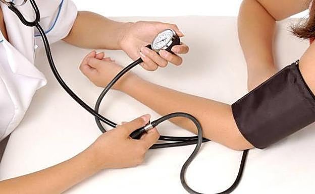 Enfermera toma la tensión arterial de una paciente. 