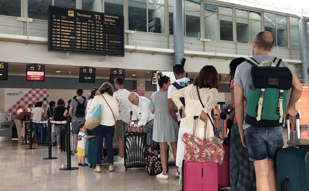 Pasajeros del vuelo de Volotea suspendido hacen cola en el aeropuerto de Asturias.