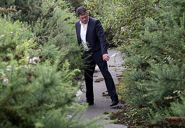 Sergio Huerta muestra una carretera de dos carriles en Santa Marina de Piedramuelle comida por la maleza en el que apenas puede pasar una persona. 