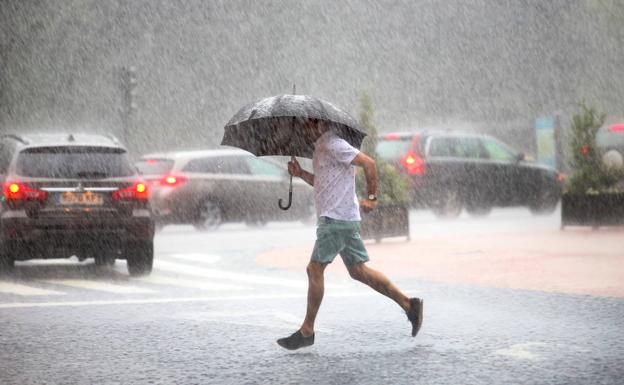 Un joven, bajo las lluvias que inundaron Oviedo esta semana. 