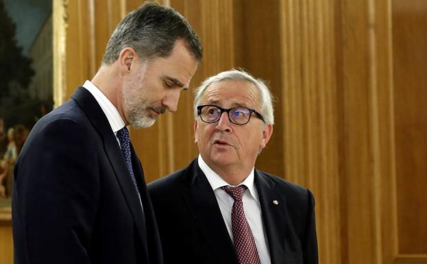 El rey Felipe (i) escucha al presidente de la Comisión Europea, Jean-Claude Juncker. 