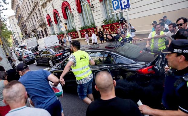Varios taxistas increpan a un coche frante al hotel Palace de Barcelona.