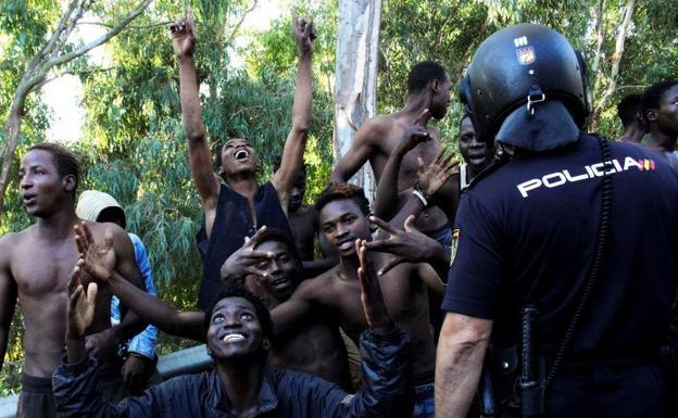 Tras saltar la valla, los inmigrantes celebran su llegada a Ceuta.