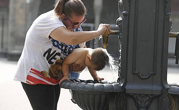 Imagen. El Entrego. Una joven refresca a su hermano en una fuente. :