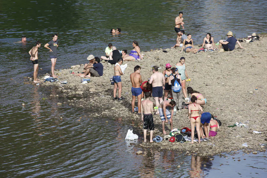 Miles de personas disfrutan de la popular fiesta del Xiringüelu en el prau Salcéu de Pravia en una jornada marcada por el sol y el intenso calor. 