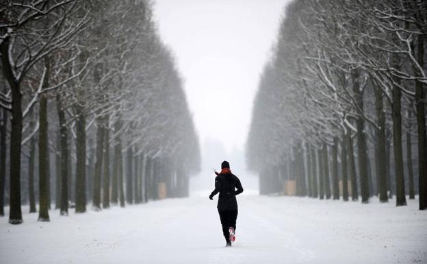 Mujer hace ejercicio en un parque cubierto de nieve.