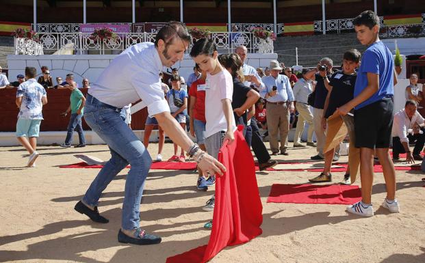 El diestro Juan José Padilla enseña a un niño en la plaza de toros de El Bibio.