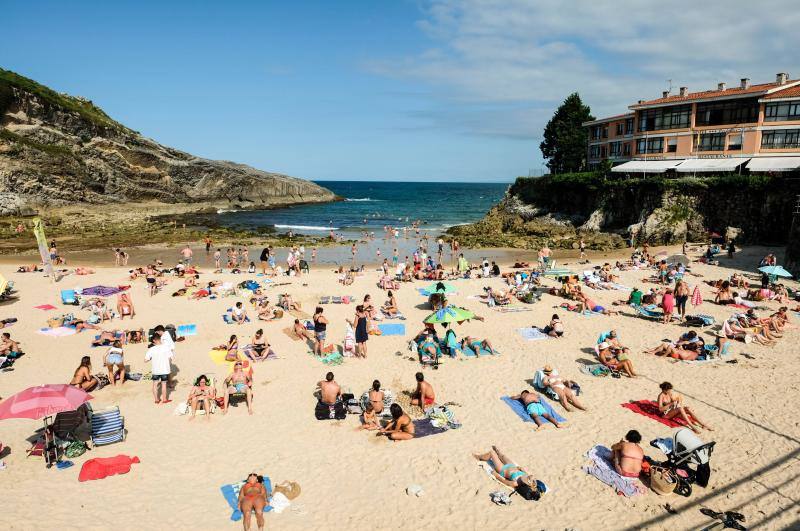 El sol y el calor anunciados para este fin desemana han llenado las playas de Asturias. En San Lorenzo, por ejemplo, miles de personas disfrutan del arenal y del paseo del Muro.