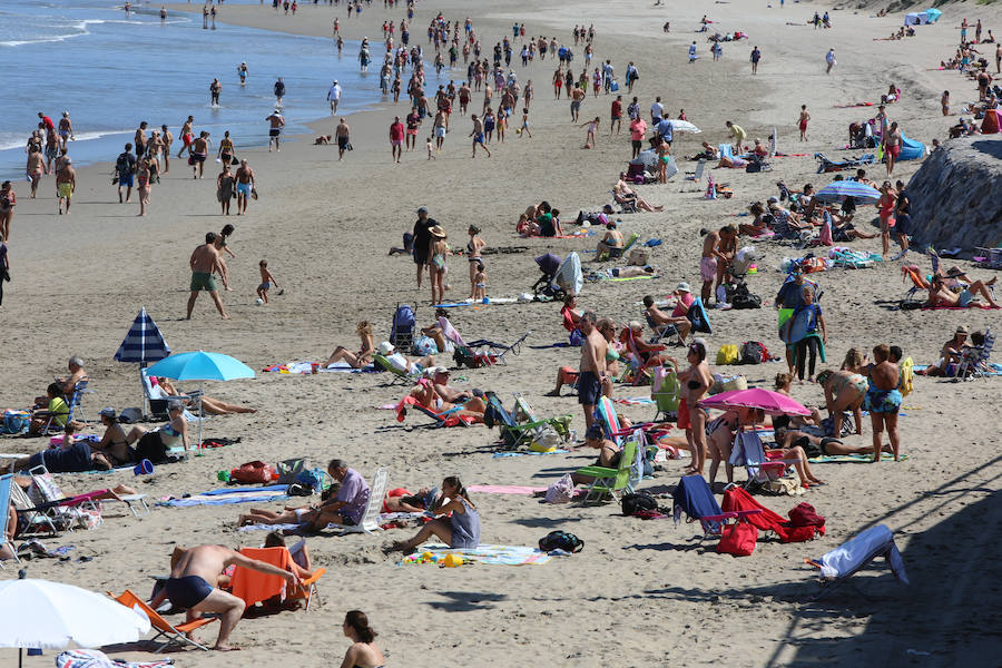 El sol y el calor anunciados para este fin desemana han llenado las playas de Asturias. En San Lorenzo, por ejemplo, miles de personas disfrutan del arenal y del paseo del Muro.