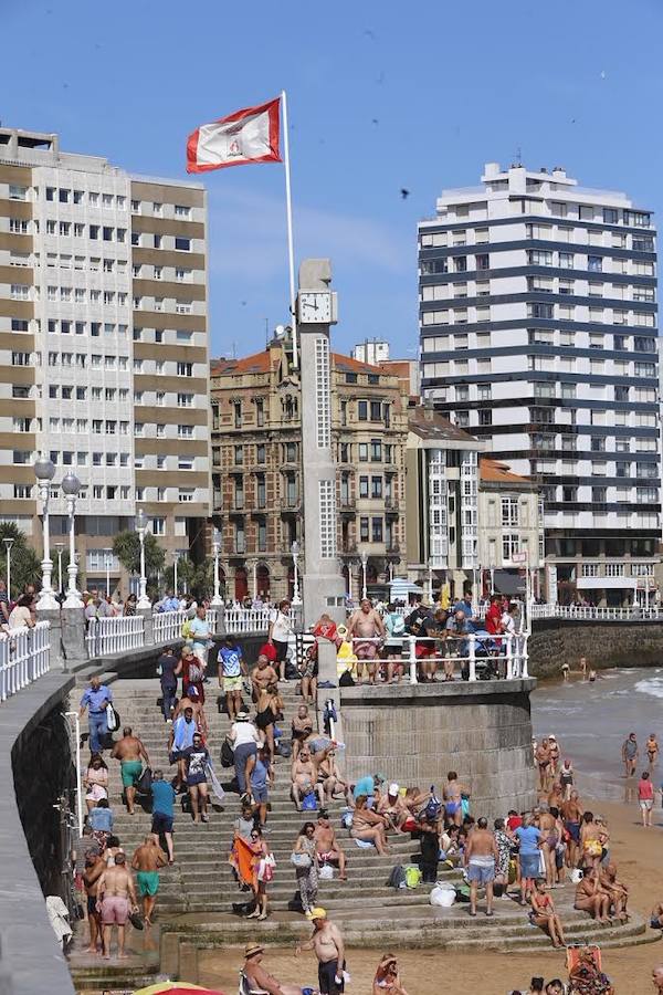 El sol y el calor anunciados para este fin desemana han llenado las playas de Asturias. En San Lorenzo, por ejemplo, miles de personas disfrutan del arenal y del paseo del Muro.