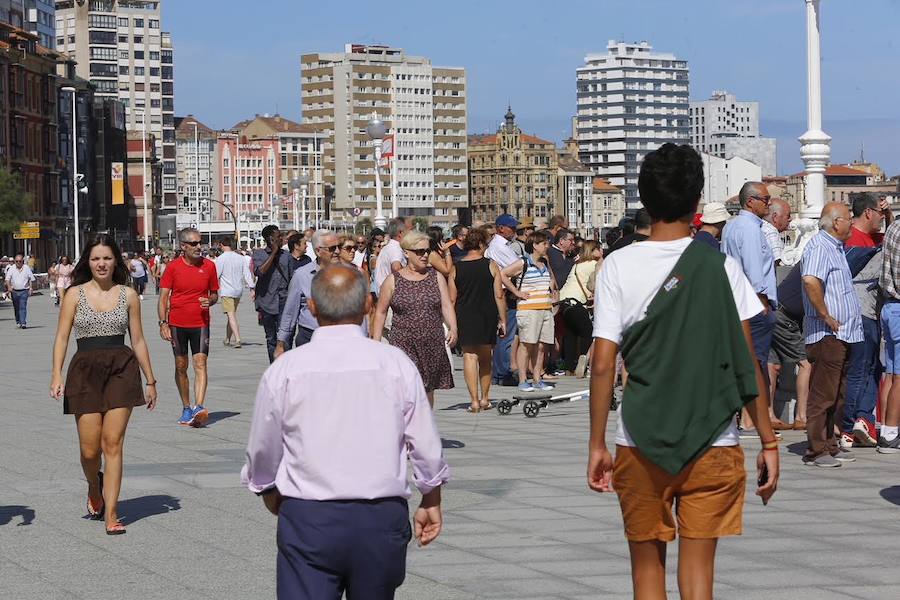 El sol y el calor anunciados para este fin desemana han llenado las playas de Asturias. En San Lorenzo, por ejemplo, miles de personas disfrutan del arenal y del paseo del Muro.