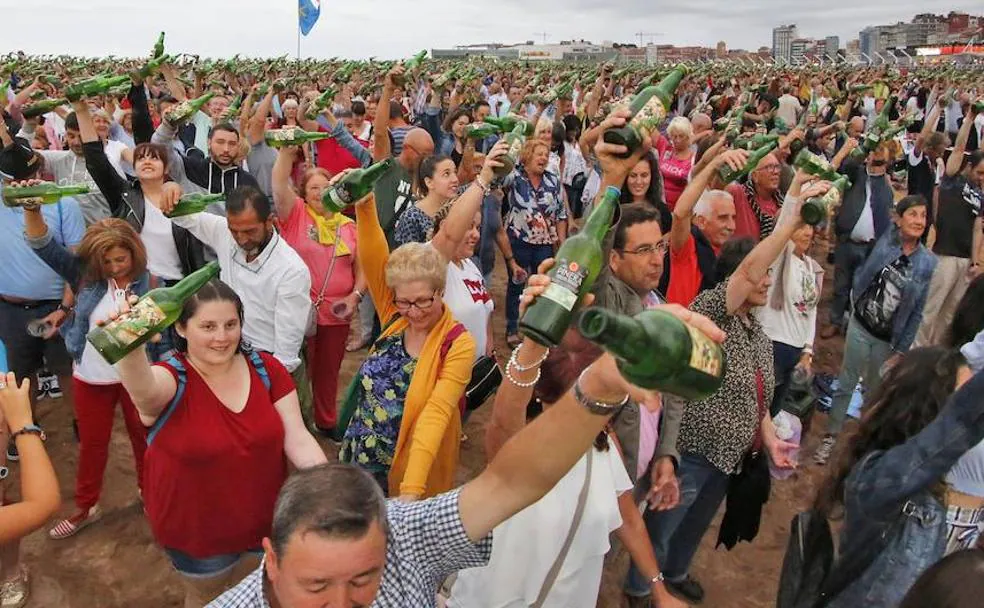 Los participantes escanciando los miles culinos de sidra que dieron el récord a Gijón.