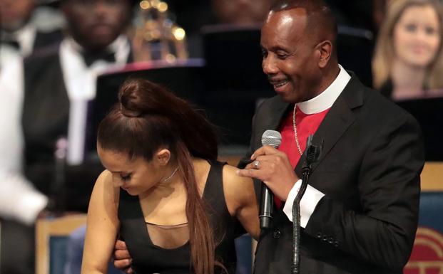 Ariana Grande (i) reacciona al sentir la mano de Charles Ellis. 