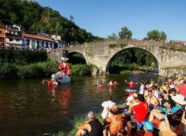 Público y participantes, en la última edición del Descenso Folklórico del Nalón, en el puente de la Chalana. 