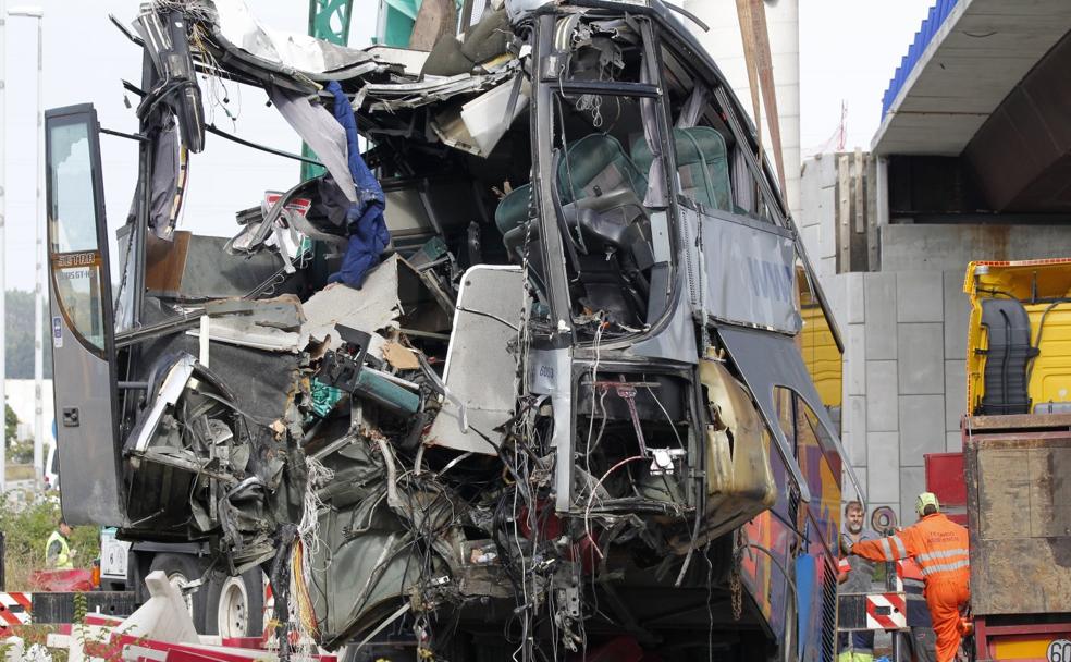 Una grúa de grandes dimensiones retira el autobús accidentado, horas después de que se empotrase contra una columna, en Llaranes. 