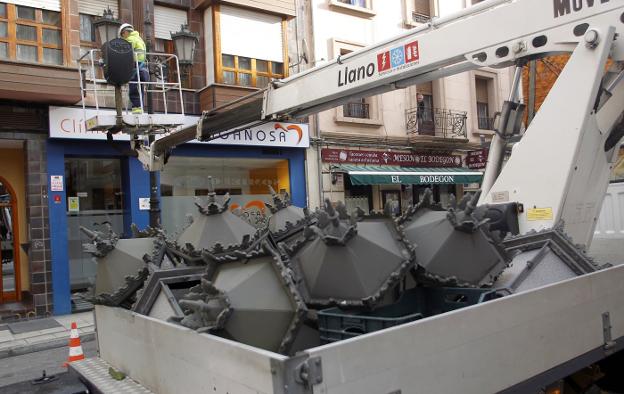 Un operario cambiando una de las farolas en la ciudad. 