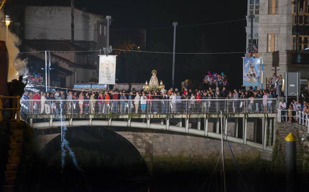 La Virgen de La Guía a su paso por el puente de Llanes en su camino hacia la basílica, arropada por la comitiva de simpatizantes del bando. 