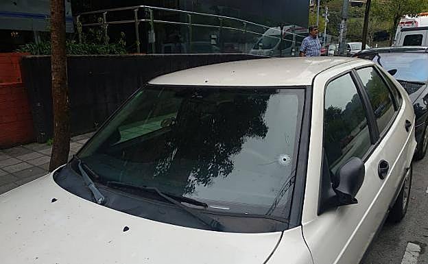 Impactos de la bala en la luna y en el techo del turismo, justo encima del espejo retrovisor.