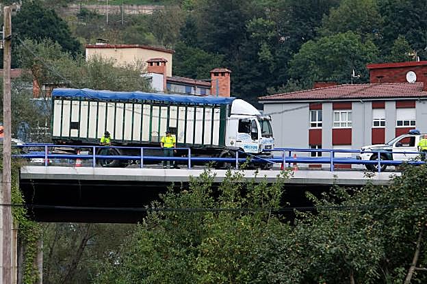 Varios agentes de la Guardia Civil, junto al camión implicado en el accidente. 