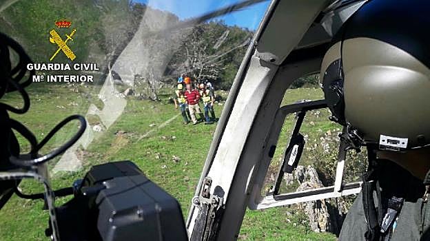 El evacuado, con camisa a rayas, ante el helicóptero. 