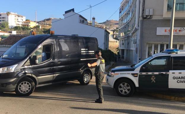 Una furgoneta de los servicios funerarios abandona el lugar en el que ha sido hallado el cadáver de una mujer en Torrox.