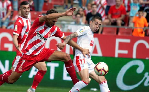 El delantero uruguayo del Girona Christian Stuani (i) disputa el balón con el centrocampista del Eibar, Rubén Peña.