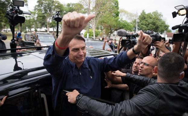 Jair Bolsonaro saluda a sus seguidores tras depositar su voto.