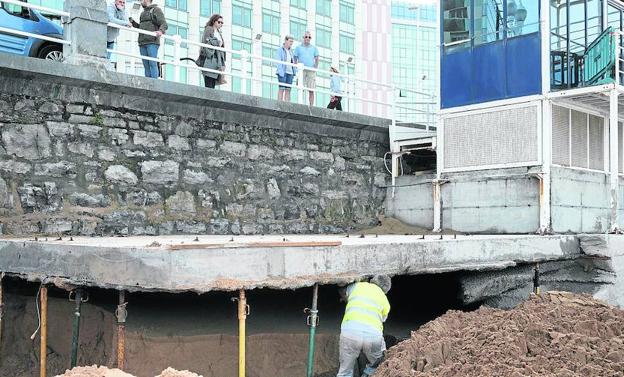 Un trabajador municipal revisa los puntales colocados ayer para sustentar la plataforma de la caseta de salvamento