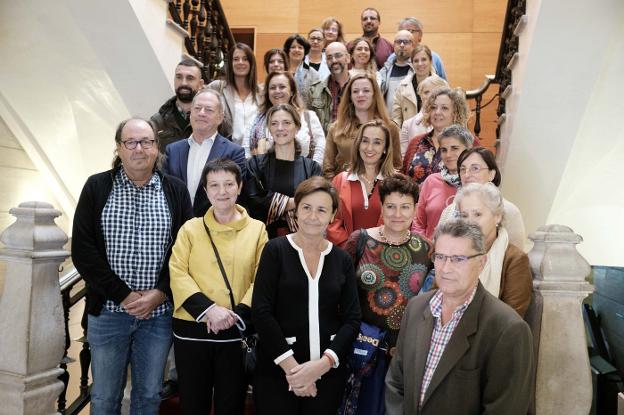 Representantes de los centros participantes y de los grupos municipales, con Feli Soria (de amarillo), la alcaldesa Carmen Moriyón y Jorge Antuña, primero por la derecha, en el Consistorio. 