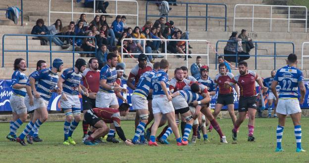 Los jugadores de ambos equipos en una lucha por el oval. 