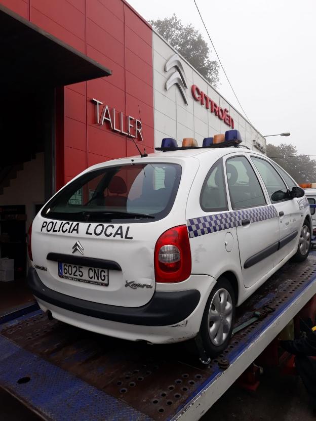 El coche, frente al taller. 