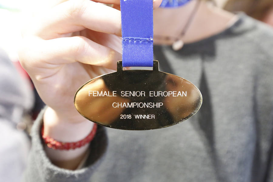 Fueron recibidas en el Aeropuerto de Asturias por un grupo de aficionados. Llegaron con las medallas que acreditan el título europeo logrado en Portugal. 