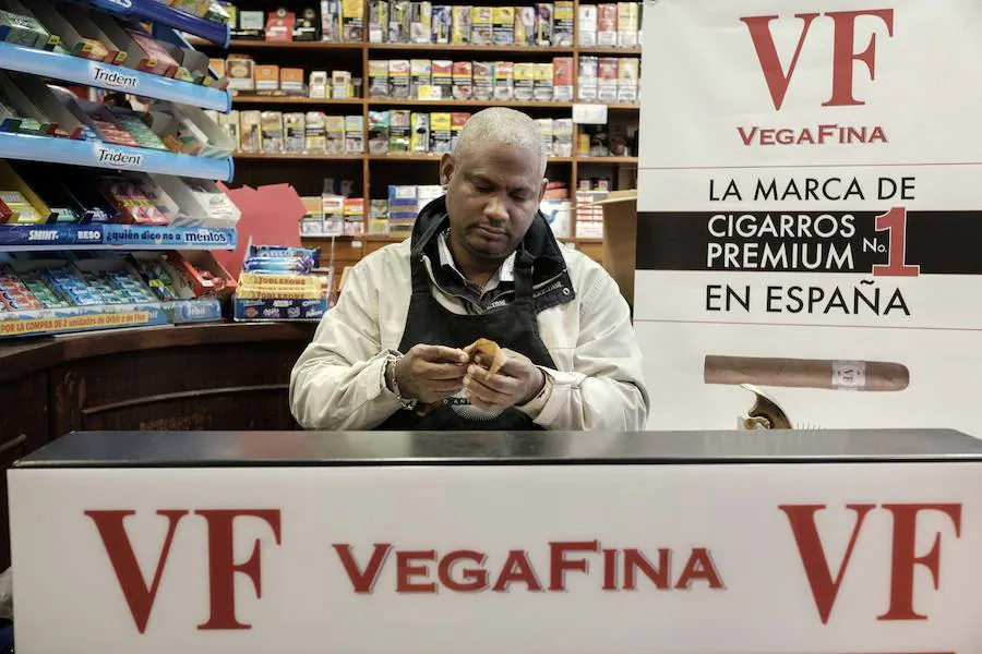 El maestro torcedor dominicano Roberto Mota sorprende a los clientes del estanco de Corrida, en Gijón, con una exhibición de torcido de puros