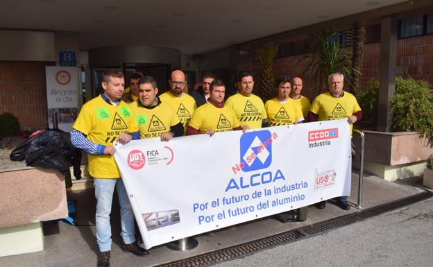 El comité de empresa de la factoría de Avilés posa con su pancarta justo antes de reunirse con los representantes de Alcoa.
