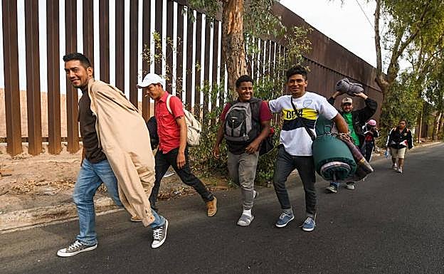 ecenas de migrantes centroamericanos caminan hoy junto a la valla fronteriza de la ciudad norteña de Mexicali rumbo a la ciudad de Tijuana. 