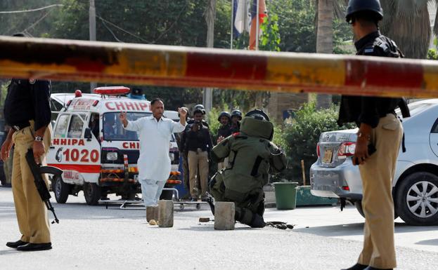 Artificieros registran una bolsa tras el ataque al Consulado chino en Karachi.