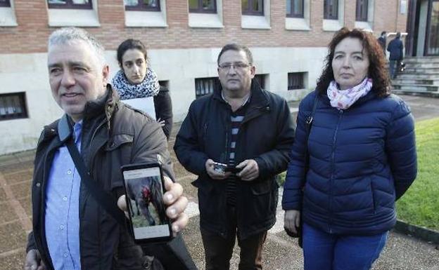 Fernando Marrón muestra, a las puertas del juzgado, los daños sufridos por un animal. Detrás, los ganaderos afectados. / MARIO ROJAS