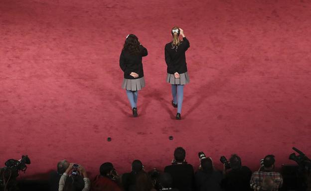 Dos niñas cantan uno de los premios en la Lotería de Navidad. 