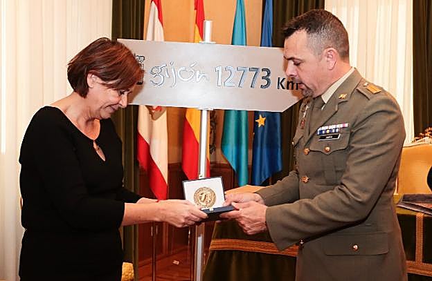 La alcaldesa y el brigada Jaime Albela, junto a la señal con el nombre de Gijón que llevará a la Antártida. 